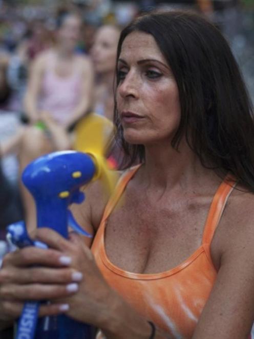 Toni Ann Gaggi uses an electric fan to escape the heat in Times Square in New York. REUTERS...