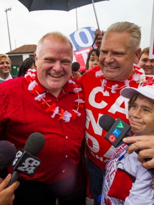 Toronto Mayor Rob Ford (C) and his brother Doug take part in the East York Canada Day Parade in...