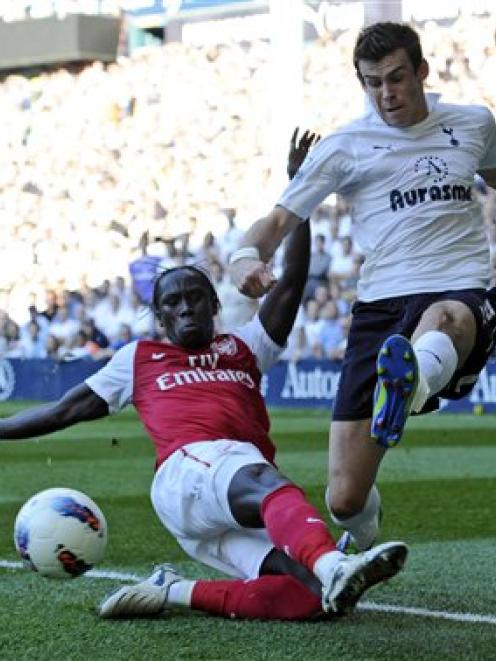 Tottenham Hotspur's Gareth Bale, right, crosses the ball past Arsenal's Bacary Sagna during their...