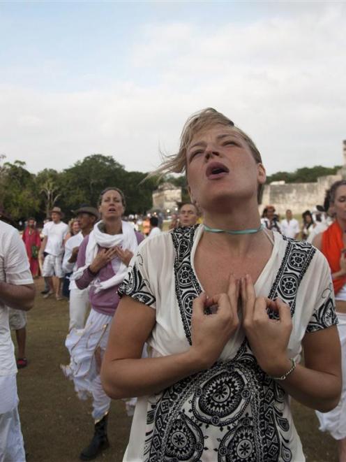 Tourists meditate at the archaeological zone of Chichen Itza in Mexico where thousands of mystics...