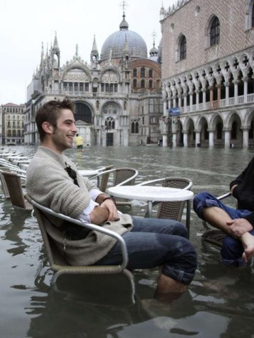 Tourists sit in St Mark's Square in Venice earlier this week as exceptionally high tides brought...