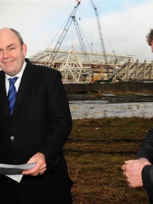 Transport Minister Steven Joyce (centre) checks the site of a planned roundabout, to be built as...