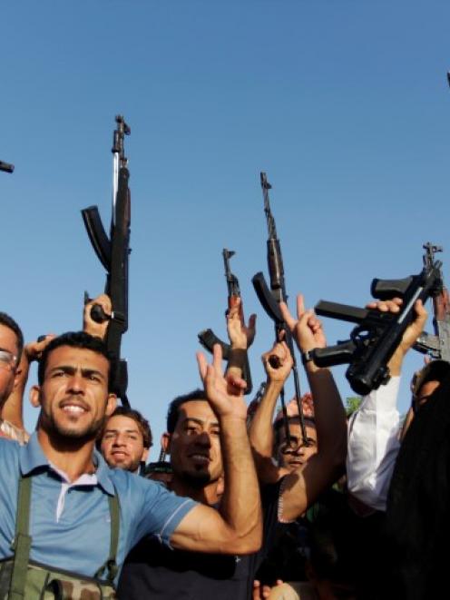 Tribal fighters shout slogans while holding weapons in Basra, southeast of Baghdad. REUTERS/...