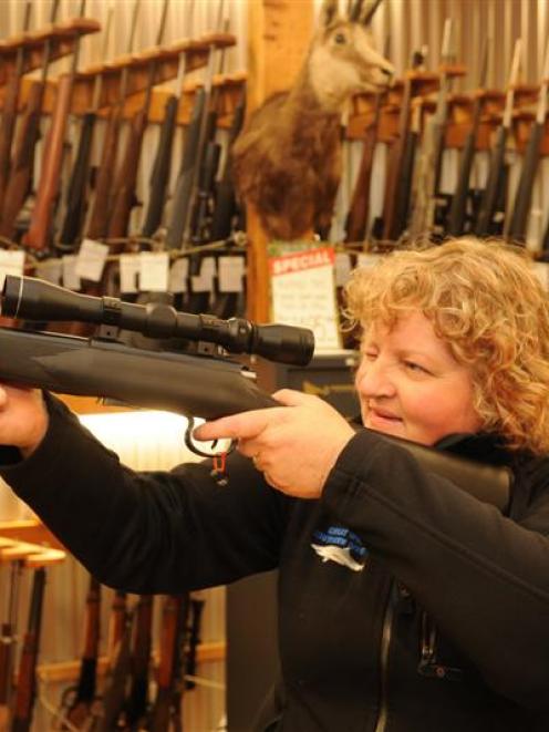 Trixie Scott, of Dunedin, check the sights on a .22 rifle at Allan Millar's Hunting and Fishing...