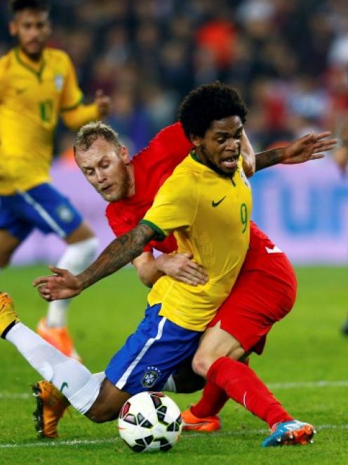 Turkey's Semih Kaya fouls Brazil's Luiz Adriano (R) during their international friendly at Sukru...