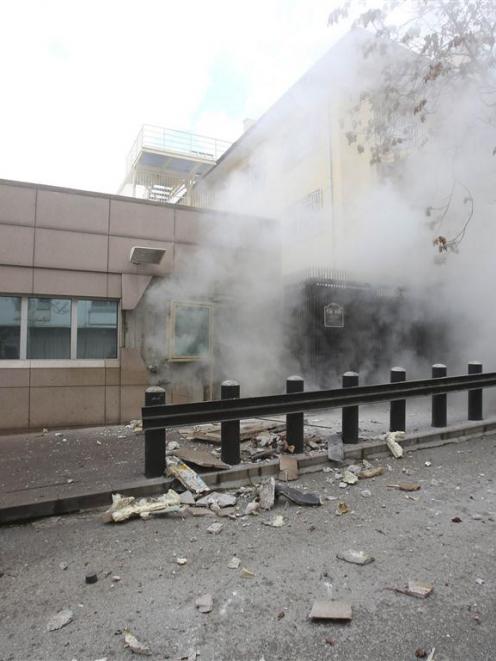 Turkish police officers react after an explosion at the entrance of the US Embassy in Ankara....