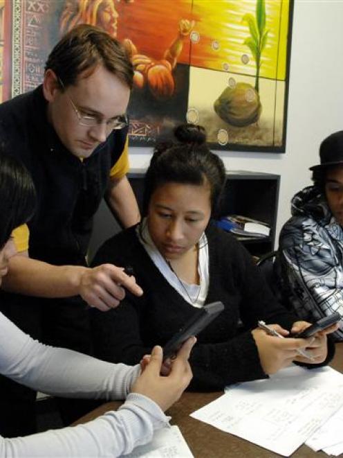 Tutor Timothy Ball (second from left) helps (from left) Faiumu Pavahi, Lisa Lam Cheung and...