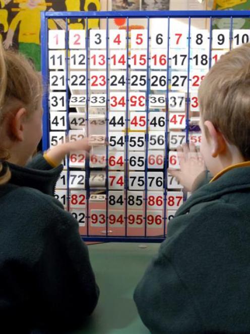 Two 5-year-old Dunedin pupils play with a number board at school. Photo by Gregor Richardson.