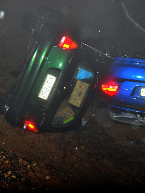 Two cars in a ditch after part of Highcliff Rd was swept away from in front of them last night....
