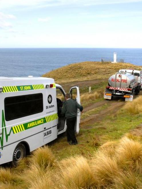 Two men stand near the ambulance which contains the body of their friend who drowned after being...
