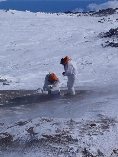 Two scientists take soil samples at Tramway Ridge. Photos by Craig Cary.