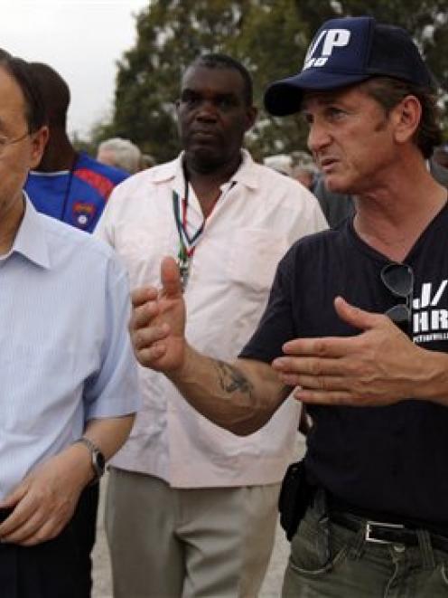 U.N Secretary-General Ban Ki-moon, left, listens to US actor Sean Penn during his visit to a...