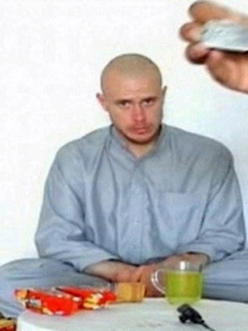 U.S. Army Private Bowe Bergdahl watches as one of his captors display his identity tag to the...