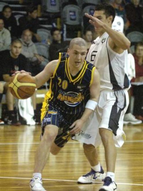 uggets point guard Scott O'Gallagher (left) drives past Hawks captain Jarrod Kenny during their...