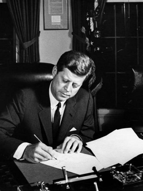 United States president John F. Kennedy signs a proclamation authorising the naval blockade of...