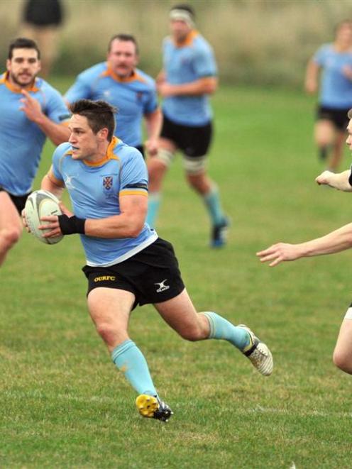 University A first five-eighth Stephen Fenemor makes a break as Pirates winger Rory O'Brien moves...