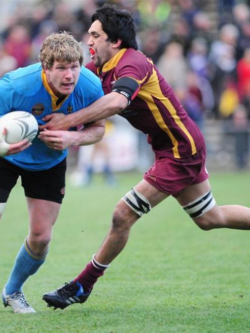 University A flanker Adam Thomson is tackled by Alhambra-Union loose forward Wahari Waitohi in...
