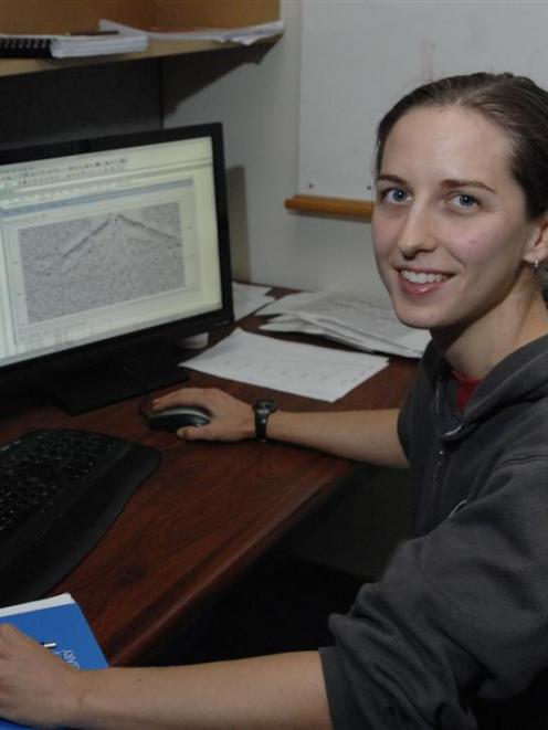University of Otago geophysics student Joanna Cooper sits beside computer screens displaying...