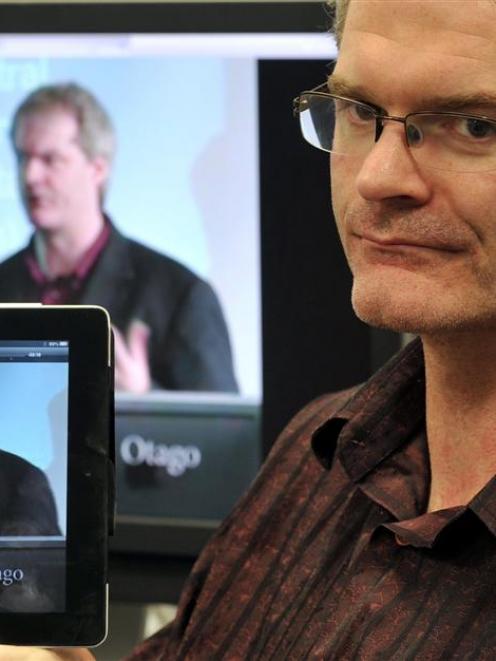 University of Otago information technology manager Emerson Pratt holds up an iPad playing a...