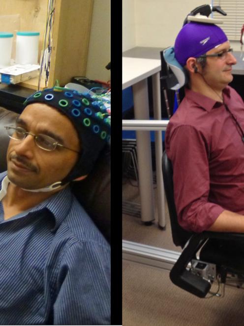 University of Washington researcher Rajesh Rao, left, plays a computer game with his mind. Across...