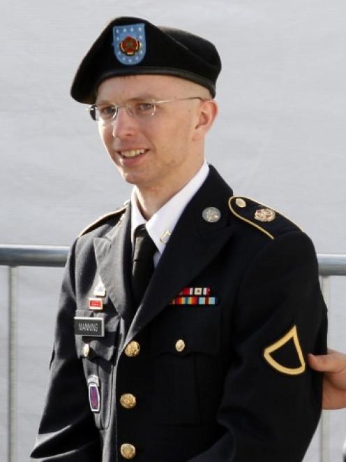 US Army Private First Class Bradley Manning (C) is escorted in handcuffs as he leaves the...