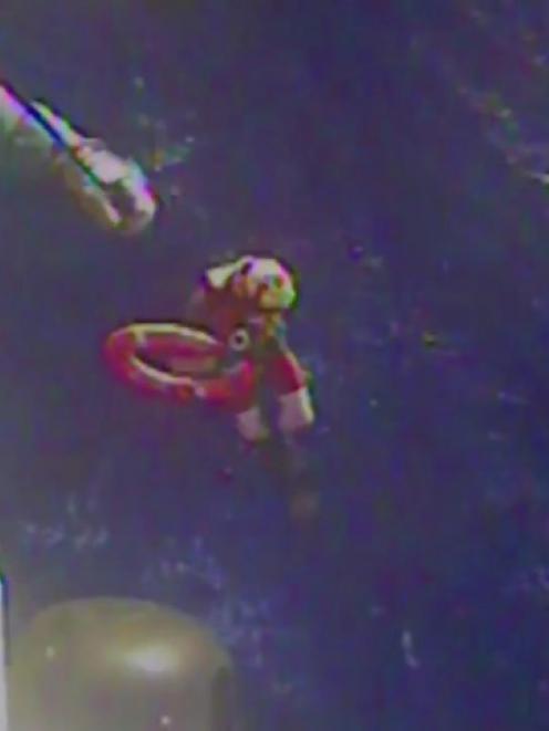 US Coast Guard members retrieve a life preserver ring believed to be from the cargo ship El Faro...