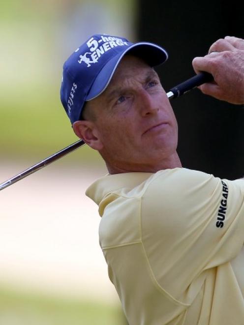 US golfer Jim Furyk watches his tee shot on the par three fifth hole during the first round at...