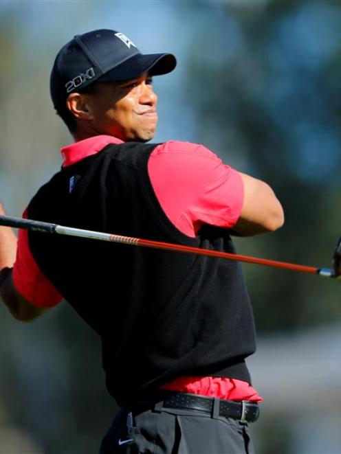 US golfer Tiger Woods lets go of his driver on his follow through while hitting off the 9th tee...