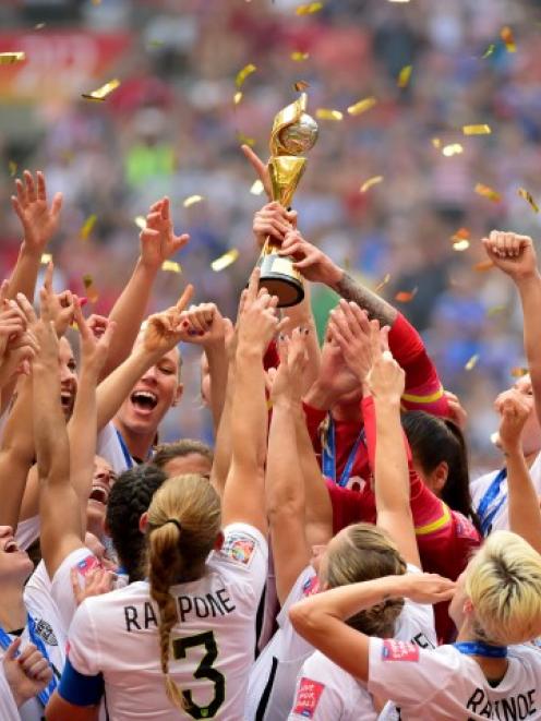 US players celebrate with the trophy after their win over Japan. Photo: Anne-Marie Sorvin-USA...