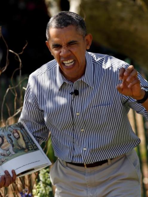 US President Barack Obama acts out a line while reading 'Where the Wild Things Are' during the...