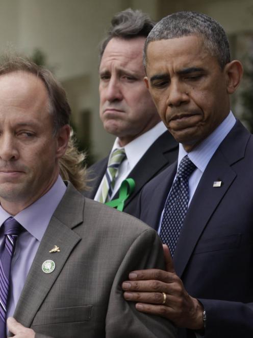 US President Barack Obama (R) comforts Mark Barden, the father of Newtown shooting victim Daniel,...
