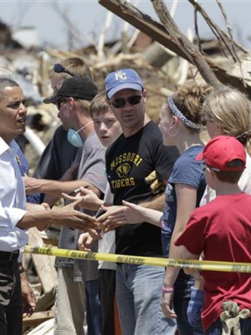 US President Barack Obama talks to residents and views damage from the tornado that devastated...