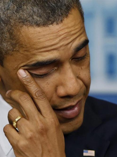 US President Barack Obama wipes a tear as he speaks about the shooting at Sandy Hook Elementary...