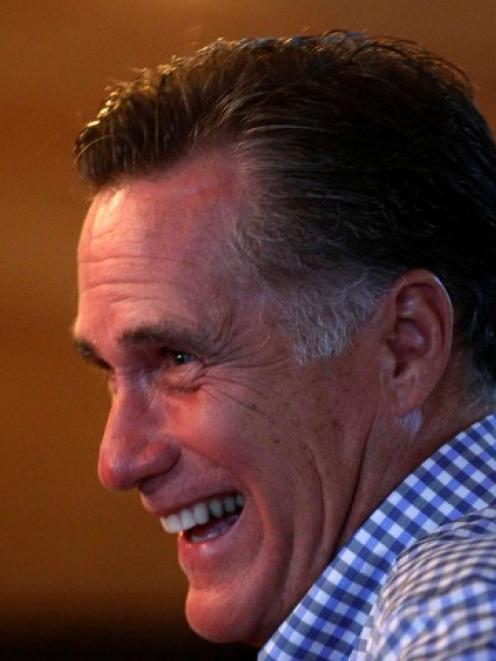 US Republican presidential nominee and former Massachusetts Governor Mitt Romney laughs as he...