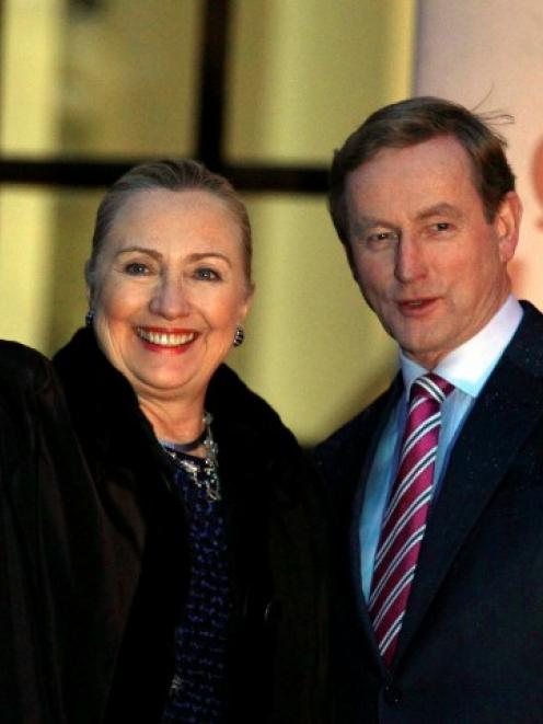 US Secretary of State Hillary Clinton is greeted by Irish Prime Minister Enda Kenny (R) as she...