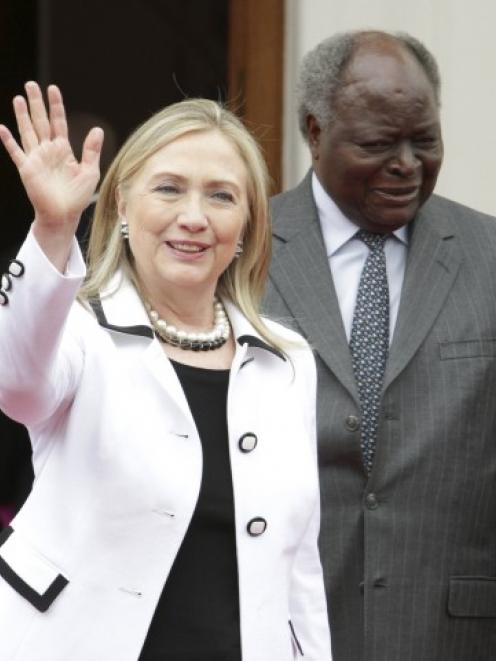 US Secretary of State Hillary Clinton waves after meeting with Kenya's President Mwai Kibaki at...