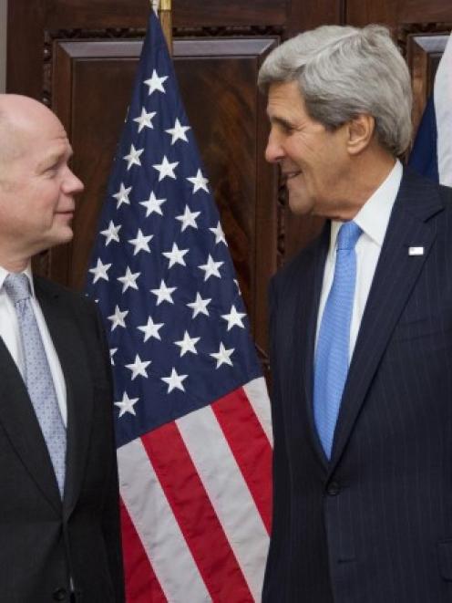 US Secretary of State John Kerry (R) talks with British Foreign Secretary William Hague at...