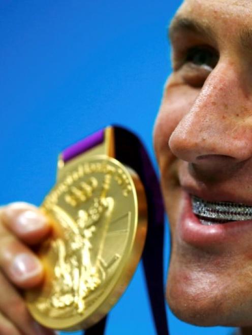 US swimmer Ryan Lochte holds his gold medal after winning the men's 400m individual medley....