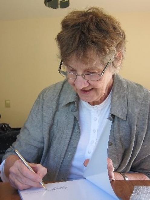 Val McMillan signs a copy of the book on old buildings of the South she co-wrote with David and...