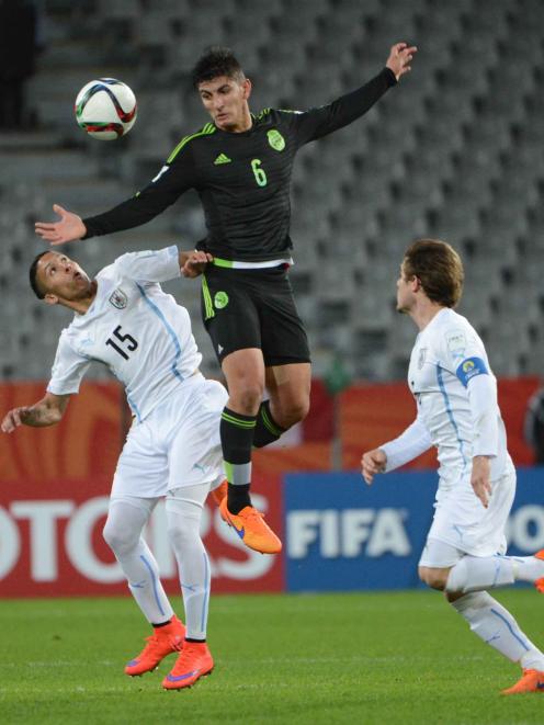 Victor Guzman, of Mexico, outjumps Uruguay's Kevin Mendez (left) as Nahitan Nandez lingers in...