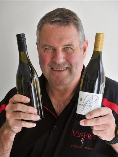 VinPro managing director Morley Hewitt holds a bottle with a standard screw cap (left) and one...