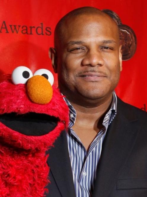 Voice actor Kevin Clash arrives with the puppet Elmo for the 2010 Peabody Award ceremony at the...
