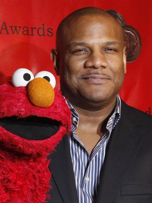 Voice actor Kevin Clash arrives with the puppet Elmo for the 2010 Peabody Award ceremony at the...