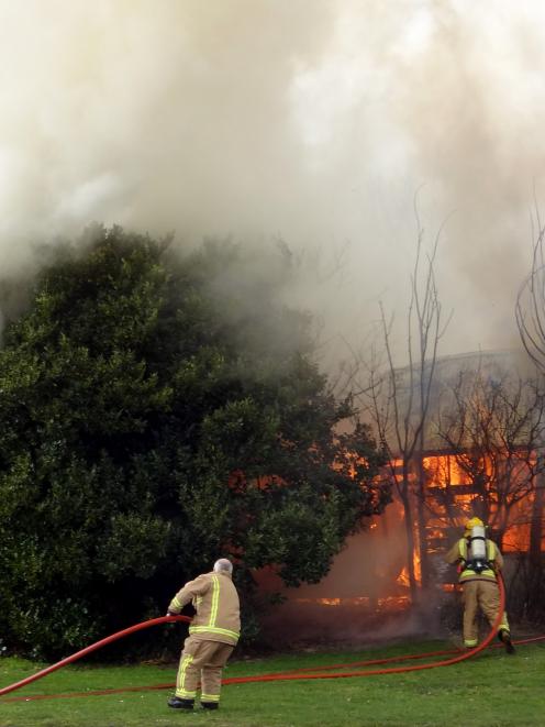 Volunteer firefighters attempt to put out a fire in Tiverton St, Palmerston, yesterday afternoon....