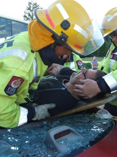 Volunteer firefighters Sam Chapman (left) and Jason Robertson move 'patient' Timothy Storm during...