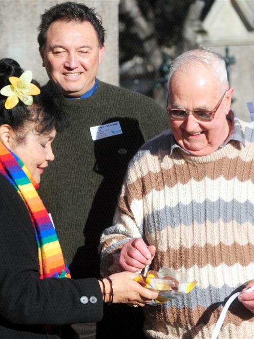 Volunteer Phil Rawson is given a biscuit by Selina Mulder, as First Church senior minister the...