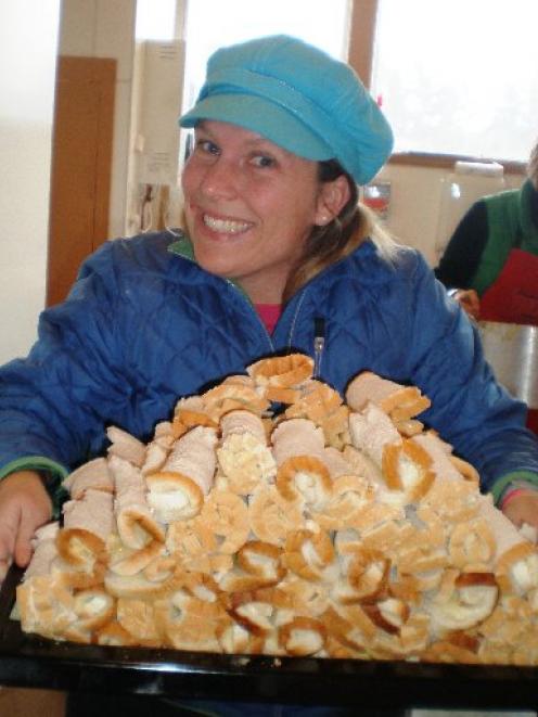 Volunteer Traci Paton holds a tray full of "cheese rolls for the teacher" during the Palmerston...