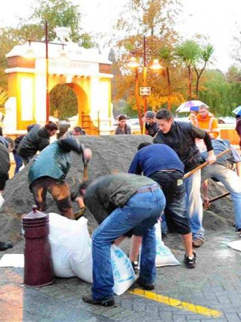 Volunteers fill sandbags on Queenstown's lakefront last night. Photo by Craig Baxter.