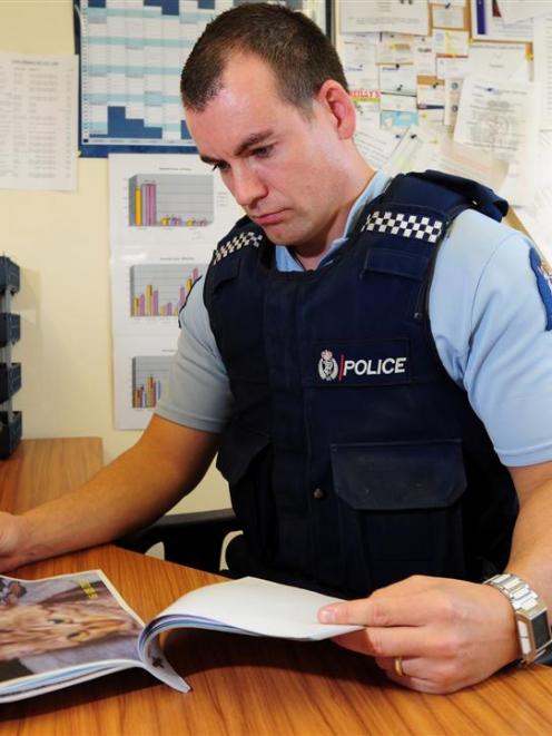 Waikouaiti's Constable Jon-Paul Tremain looks through his file on a series of cat deaths in the...