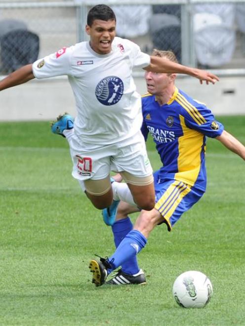 Waitakere United's Ryan de Vries is brought down in the tackle of Otago United's Craig Ferguson...